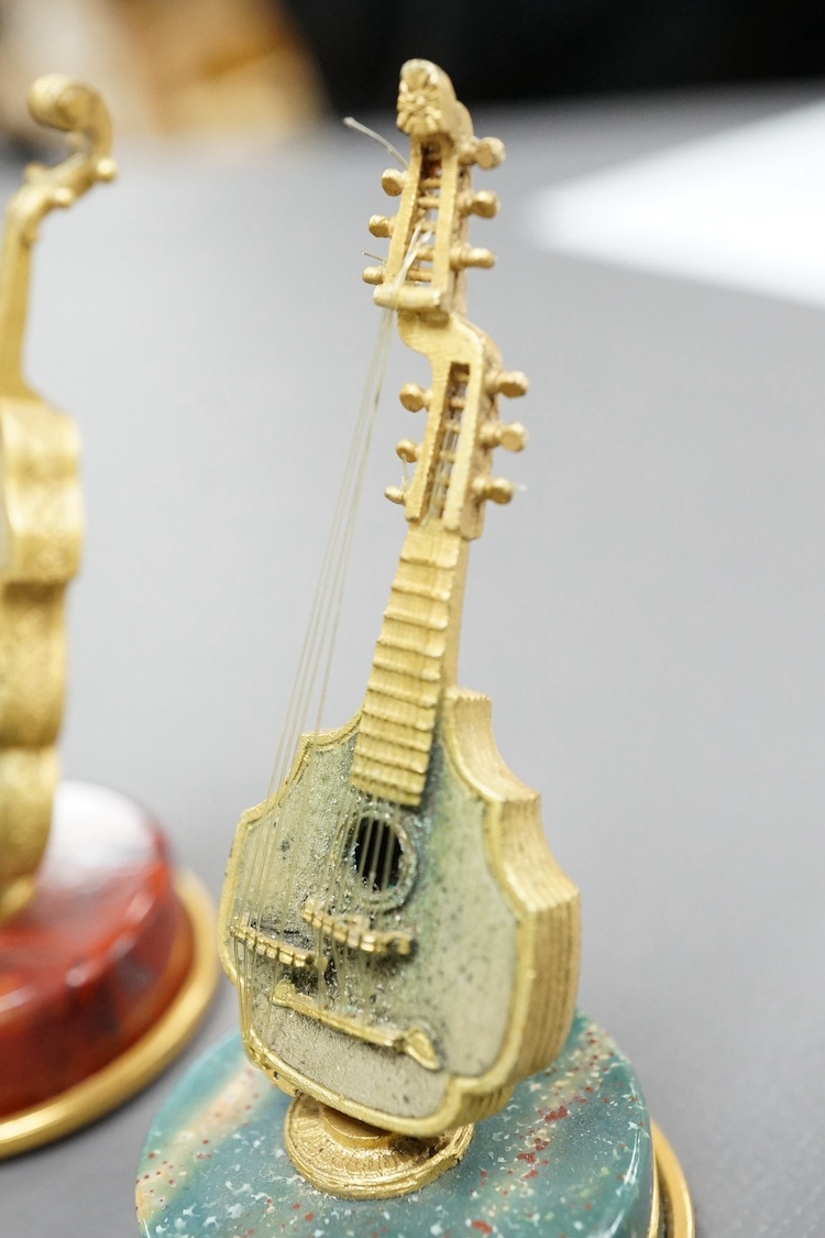 A set of four mid 20th century Italian 800 standard gilt white metal miniature model string instruments, including a lyre and lute, each mounted on a circular hardstone base, including jasper and adventurine quartz, 65mm